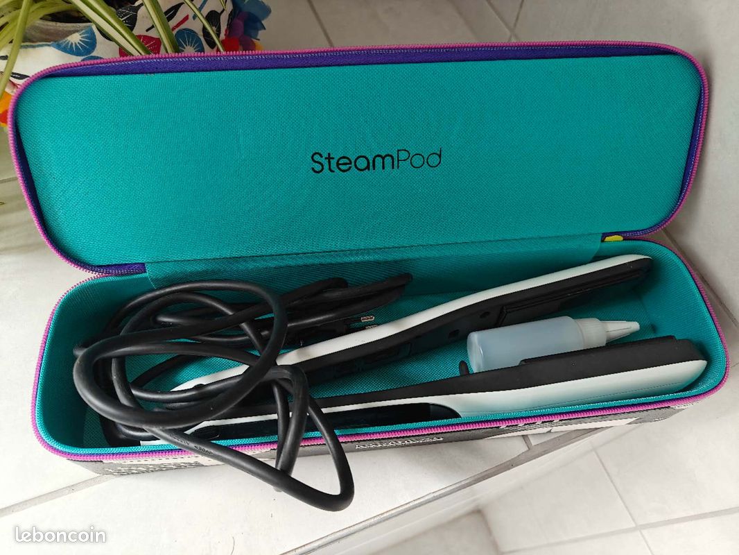 Lisseur vapeur Steampod posé sur un plan de travail clair avec son réservoir intégré