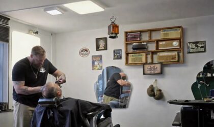 Barbier réalisant une taille de barbe précise dans un barber shop