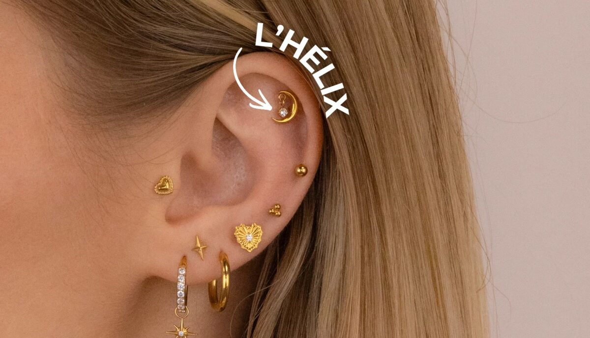 Gros plan d'un helix piercing en titane sur le cartilage supérieur de l'oreille
