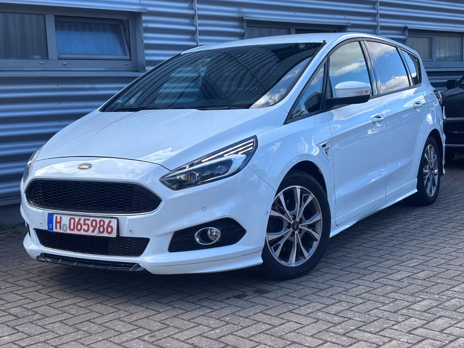 Ford C-Max gris clair vu de trois quarts avant, stationné sur un parking